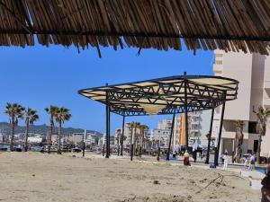 een paviljoen op een strand met palmbomen en gebouwen bij NOVA Sea View Apartments in Durrës