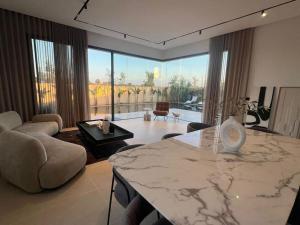 uma sala de estar com uma mesa de mármore e uma grande janela em villa em Marrakech