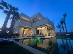 uma grande casa branca com piscina à noite em villa em Marrakech