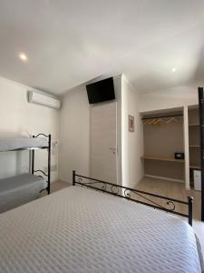 1 dormitorio con 1 cama, TV y armario en Agriturismo Tenuta la Monaca, en Aradeo