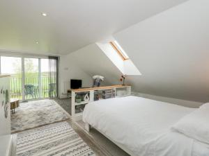 Habitación blanca con cama y ventana en Abbey Cottage en Newball