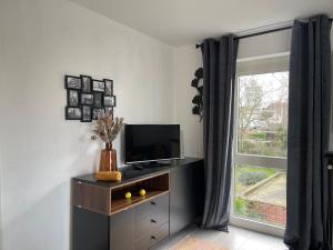 sala de estar con TV y ventana en Appartamento ideal en Tielt