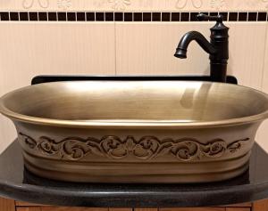 a copper sink with a faucet on a counter at REZYDENCJA BAŁTYCKA Sea and Forest KOPALINO in Kopalino