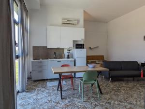een keuken en een woonkamer met een tafel en stoelen bij Monolocale Viale Arbatax in Tortolì