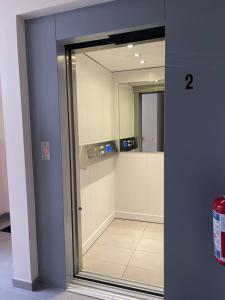 Puerta de cristal con espejo en una habitación en Appartamento ideal en Tielt