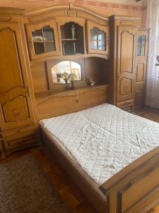 een slaapkamer met een bed en een houten kast bij Garden House etc 1 apartman 