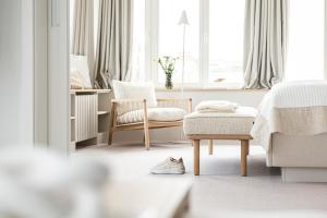 um quarto com uma cama, uma cadeira e uma mesa em Villa Astoria - Suiten am Meer em Kühlungsborn
