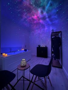 ein Zimmer mit einem Sternenhimmel-Wandbild an der Wand in der Unterkunft Cinéma & Jacuzzi aux Étoiles - CasaBianca Suite in Saint-Étienne