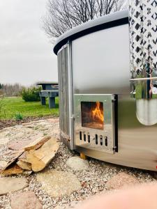 um forno exterior com um fogo dentro dele em Dižbraki em Ventspils