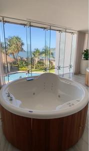 bañera grande en una habitación con ventana grande en Departamento a pie de playa en Camino al Mar en Mazatlán
