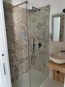 um chuveiro com uma porta de vidro ao lado de um lavatório em La caccetta em Procida
