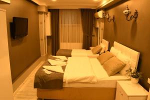 een slaapkamer met 2 bedden en een flatscreen-tv bij Californiacityhotel in Istanbul