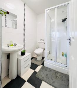 a bathroom with a toilet sink and a shower at Luxurious & Modern Apartment in Hawkhead