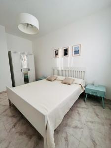 a white bedroom with a large bed and a table at Villa Clorì in Marzamemi
