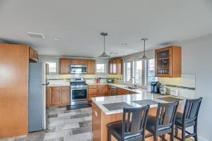 a kitchen with wooden cabinets and stainless steel appliances at Narragansett Home with Scenic Views Walk to Beach! in Narragansett