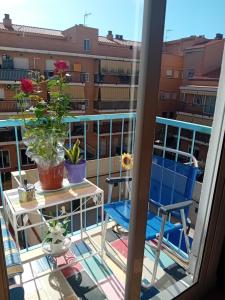 balkon z 2 krzesłami i stołem w budynku w obiekcie Apartamento compartido excelente ubicación w mieście El Prat de Llobregat