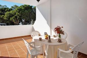 科尼爾－德拉弗龍特拉的住宿－Aptº ATALAYA , junto a la Playa，白色的桌子、白色的椅子和白色的墙壁