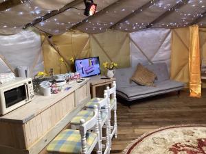 a tent with a couch and a tv in it at Vigo Retreat Yurt in Wrotham