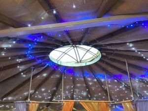 a ceiling with blue lights and a chandelier at Vigo Retreat Yurt in Wrotham