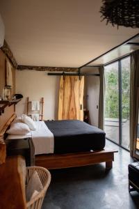 a bedroom with a bed and a large window at Bufo Alvarius in Tulum