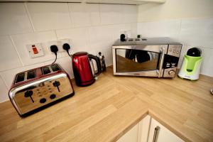 eine Küchentheke mit einem Toaster, einem Backofen und einer Mikrowelle in der Unterkunft Henry's Bed and Breakfast in Bath