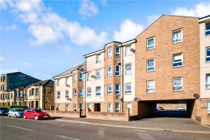 a brick building with a parking lot in front of it at Luxurious & Modern Apartment in Hawkhead