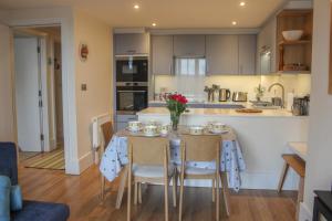 a kitchen and dining room with a table and chairs at 13 Combehaven in Salcombe