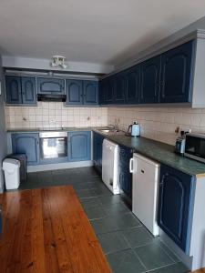 a kitchen with blue cabinets and white appliances at Dingle Town Center Apartment in Dingle