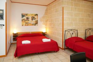 una camera rossa con 2 letti e un divano di RESIDENCE LUPIAE a Lecce