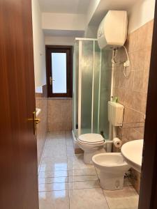 een badkamer met een toilet, een douche en een wastafel bij Fondaco House in Fondachello