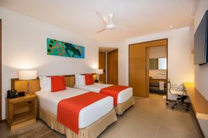a hotel room with two beds and a desk at Hotel Irotama Reservado in Santa Marta +28 photos