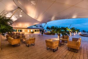 un patio al aire libre con mesas, sillas y una sombrilla grande en Hotel Irotama Reservado, en Santa Marta 36 fotos más