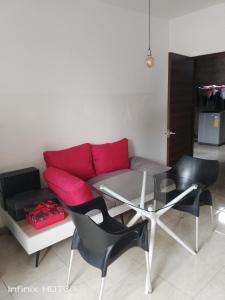 - un salon avec un canapé, une table et des chaises dans l'établissement Alojamiento y transporte, à Guayaquil