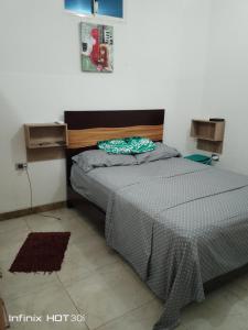 a bedroom with a bed with a gray comforter at Alojamiento y transporte in Guayaquil