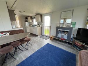 a living room with a dining room table and a kitchen at Ormesby 8, Haven Holiday Park, Caister - Four Bedroom, sleeps 8, pets welcome - 2 minutes from the beach! in Great Yarmouth