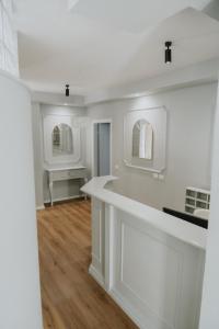 地拉那的住宿－Urban Hotel，白色的厨房配有一个柜台和两面镜子