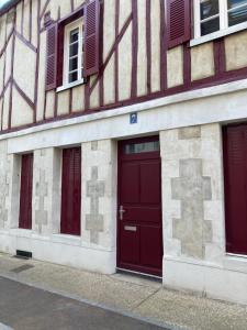 um edifício com duas portas vermelhas e janelas em L’Atelier cosy em Auxerre