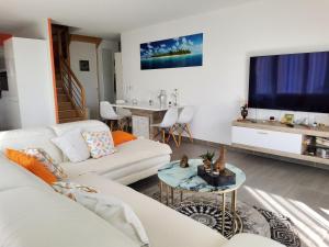 - un salon avec deux canapés blancs et une télévision dans l'établissement Magnifique rooftop duplex climatisé aux ARCEAUX, à Montpellier