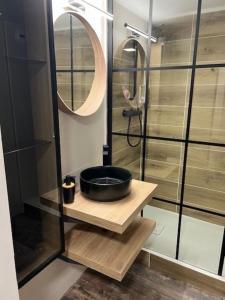 a bathroom with a black sink and a mirror at Gîte Grand'Rue "Climatisé" in Colmar