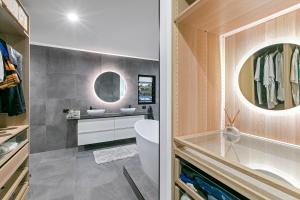 a bathroom with a sink and a toilet and a mirror at Modern Luxury Pool Oasis in Buddina