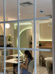 une femme assise sur une chaise et regardant son téléphone portable dans l'établissement Blu Hotel Boutique, à Lima