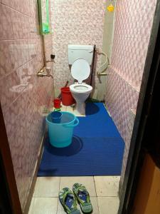 e bagno con servizi igienici e un paio di pantofole. di City Homestay a Guwahati