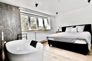 a bedroom with a bed and a bath tub in it at Chez Laure - Gîte 4-5 personnes, à 2 minutes de Durbuy in Durbuy