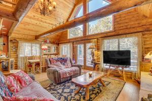 a living room with a tv and a couch and a table at Family-Friendly Cabin with Fire Pit in Forest Lakes in Forest Lakes Estates