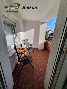 uma varanda com 2 cadeiras, uma mesa e uma janela em Fewo Helmstedt em Helmstedt