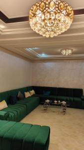 a living room with green couches and a chandelier at Medina 2 in Fez