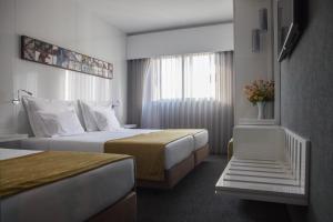 Habitación de hotel con 2 camas y ventana en Hotel Costa Verde en Póvoa de Varzim