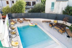 a swimming pool with chairs and a pool toy at Basilica hotel - made for fun! in Novalja