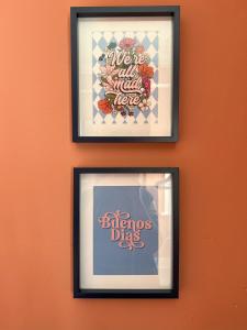 three framed pictures of flowers on an orange wall at Vibrant City Cottage in Camberwell in London