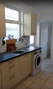 a kitchen with a sink and a washing machine at Portsmouth House near Centre 3 Bedrooms in Portsmouth